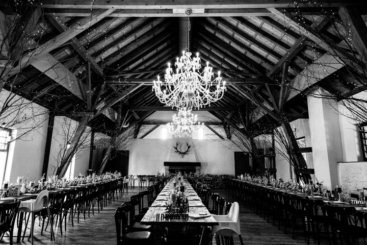 Eleganter Bankettsaal im Hofgut Maisenburg mit großen Holzbalken und einem imposanten Kronleuchter