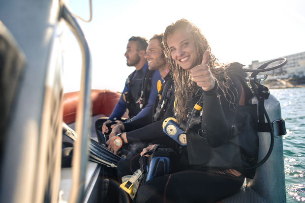 Divinggroup on boat with laughing girl onforeground