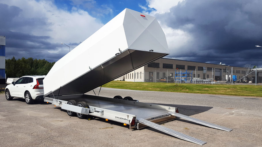 Bil med stor aluminium biltrailer som är nedsänkt med öppen kåpa