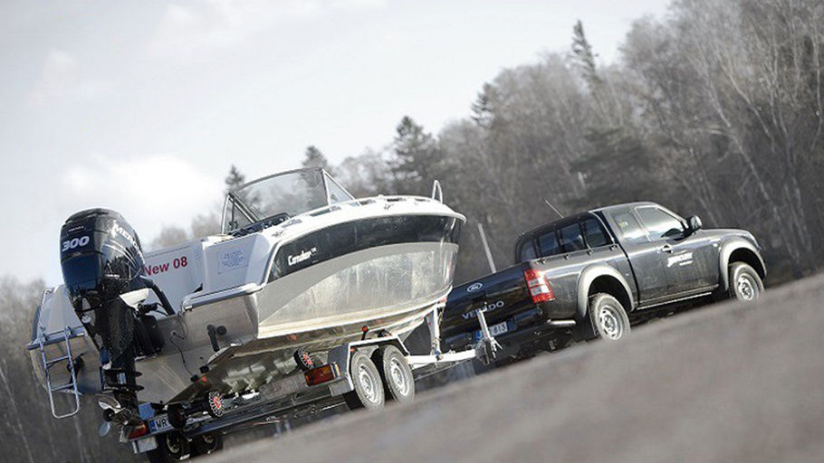 Bil med mindre båtrailer lastat med öppen utombordare