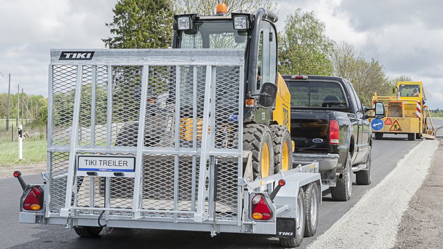 Minigrävare lastad på maskintrailer dragen av pickup