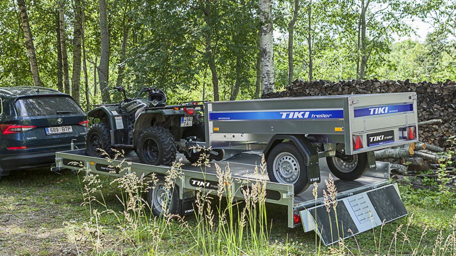 Skotersläp bakom bil lastad med ATV och mindre släpvagn