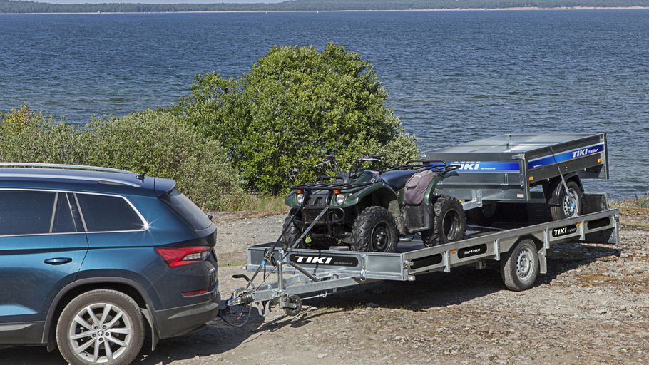 ATV på släpvagn framför sjö