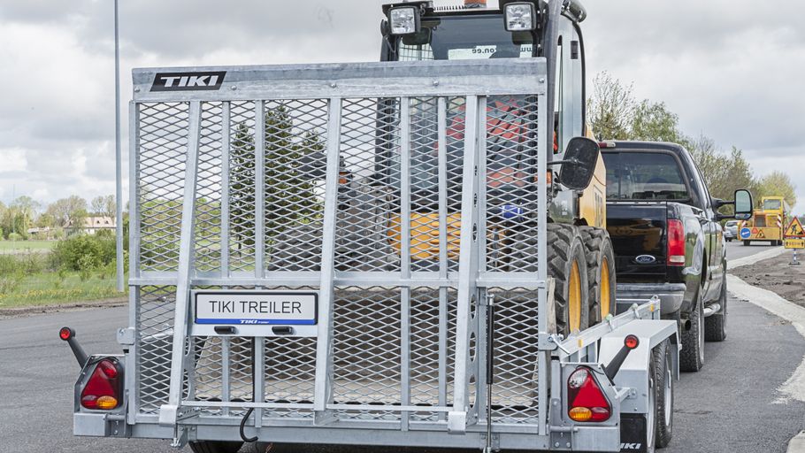 Minigrävare lastad på maskintrailer vid arbetsplats