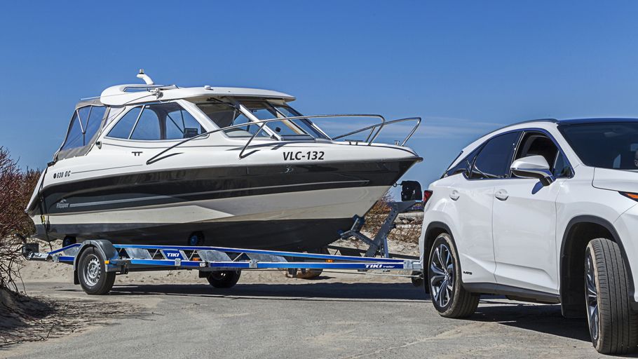 Båtrailer med lastad båt körande vid strandväg