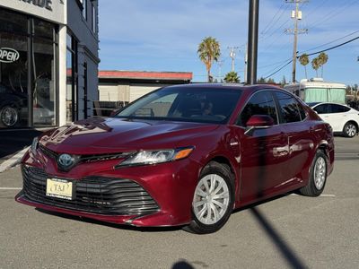 2018 Toyota Camry Hybrid in Maroon — front three-quarter view
