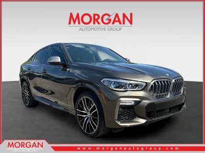 2021 BMW X6 M50i in Manhattan Green Metallic — front three-quarter view