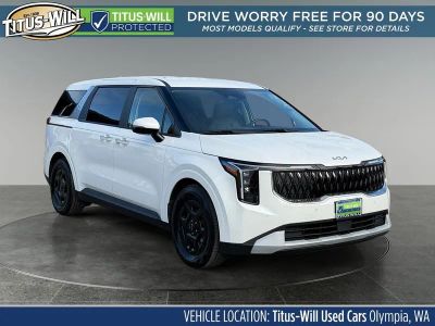 2026 Kia Carnival LXS in Snow White Pearl — front three-quarter view