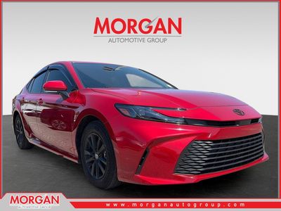 2025 Toyota Camry LE in Supersonic Red — front three-quarter view