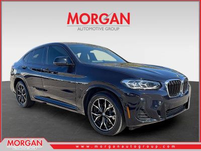 2024 BMW X4 M40i in Carbon Black Metallic — front three-quarter view