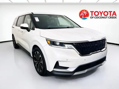 2024 Kia Carnival EX in Snow White Pearl — front three-quarter view