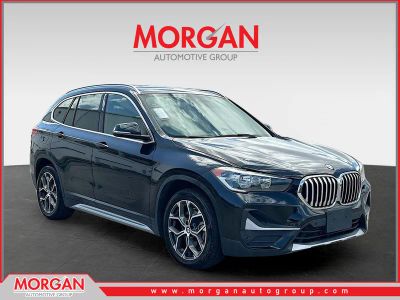 2021 BMW X1 xDrive28i in Black Sapphire Metallic — front three-quarter view
