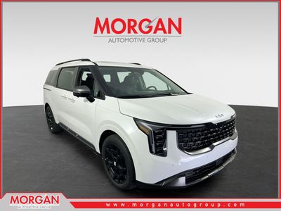 2026 Kia Carnival SX in Snow White Pearl — front three-quarter view