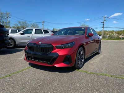 2027 BMW 5 Series 550e xDrive in Vegas Red Metallic — front three-quarter view