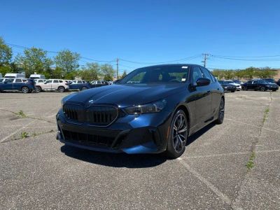 2027 BMW 5 Series 550e xDrive in Carbon Black Metallic — front three-quarter view