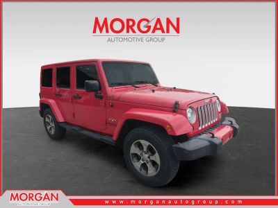 2017 Jeep Wrangler Unlimited Sahara in Red — front three-quarter view