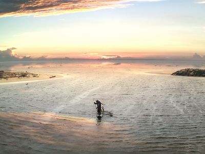 a man standing on a surfboard in the middle of a body of water