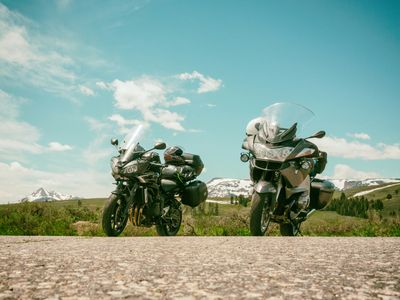 2 motorcycle parked on dirt road during daytime