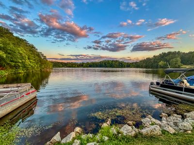 Boats docked on a serene lake at sunset.