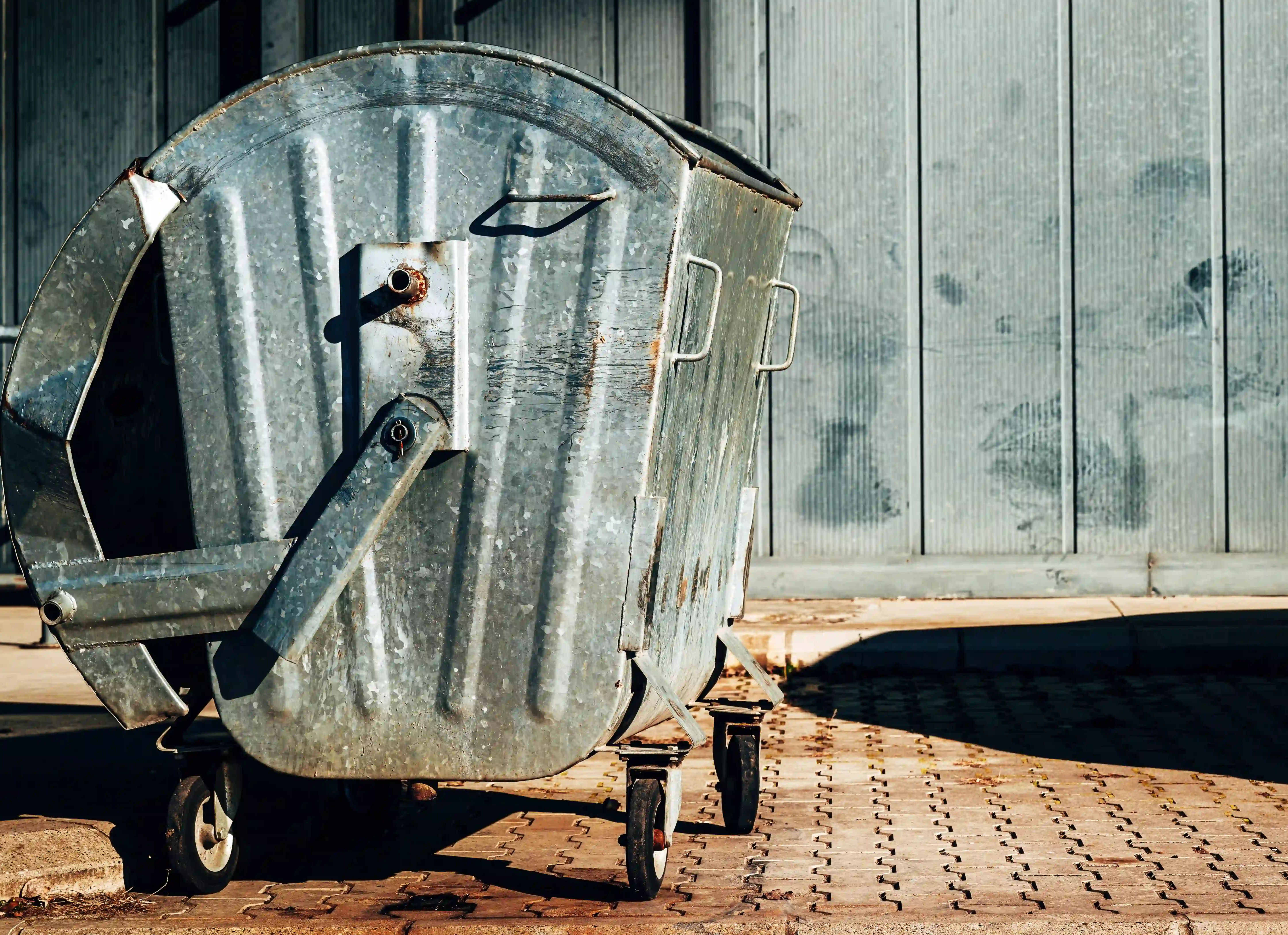 metallic-trash-dumpster-container-in-front-of-indu