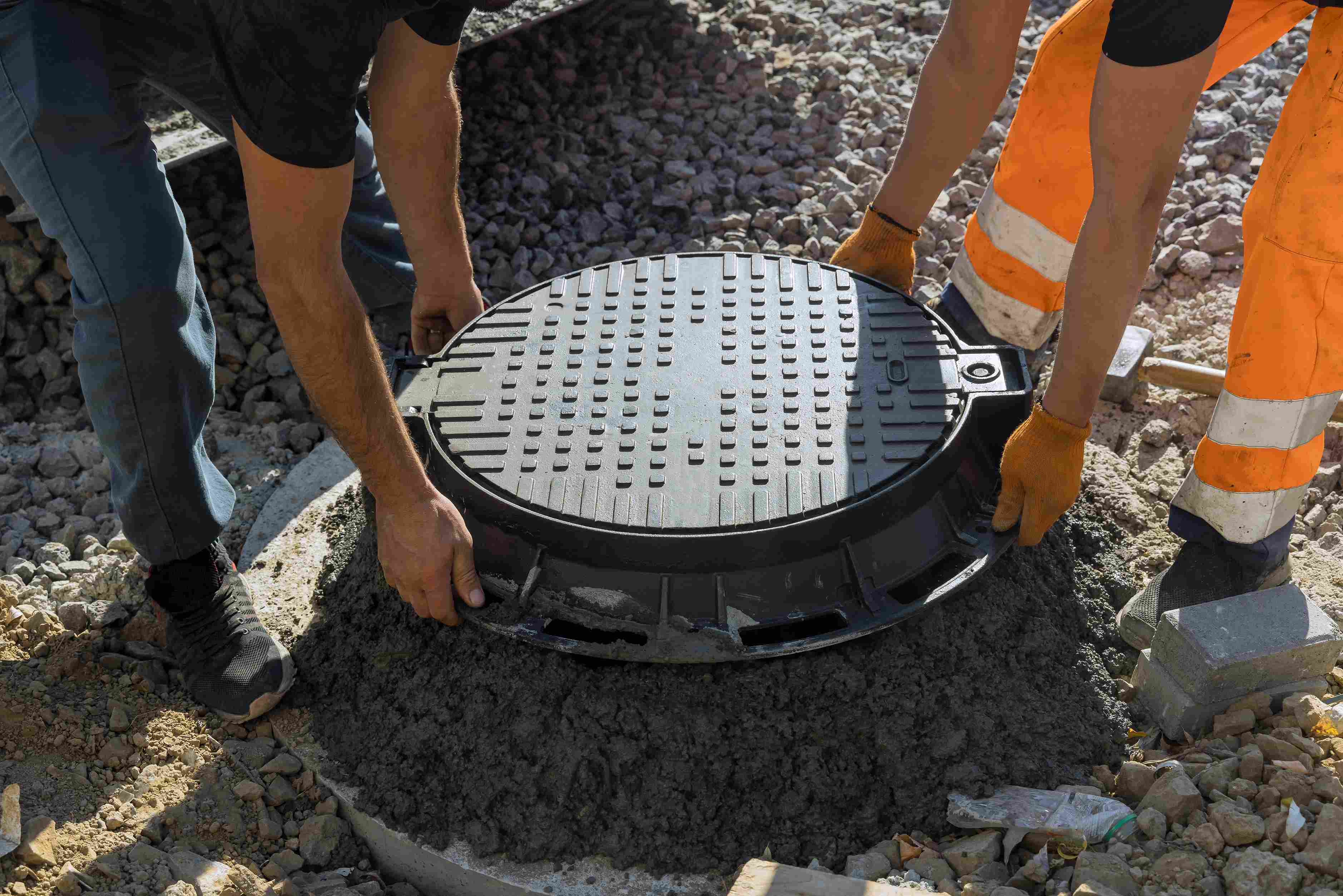 a-worker-installs-a-sewer-manhole-on-a-septic