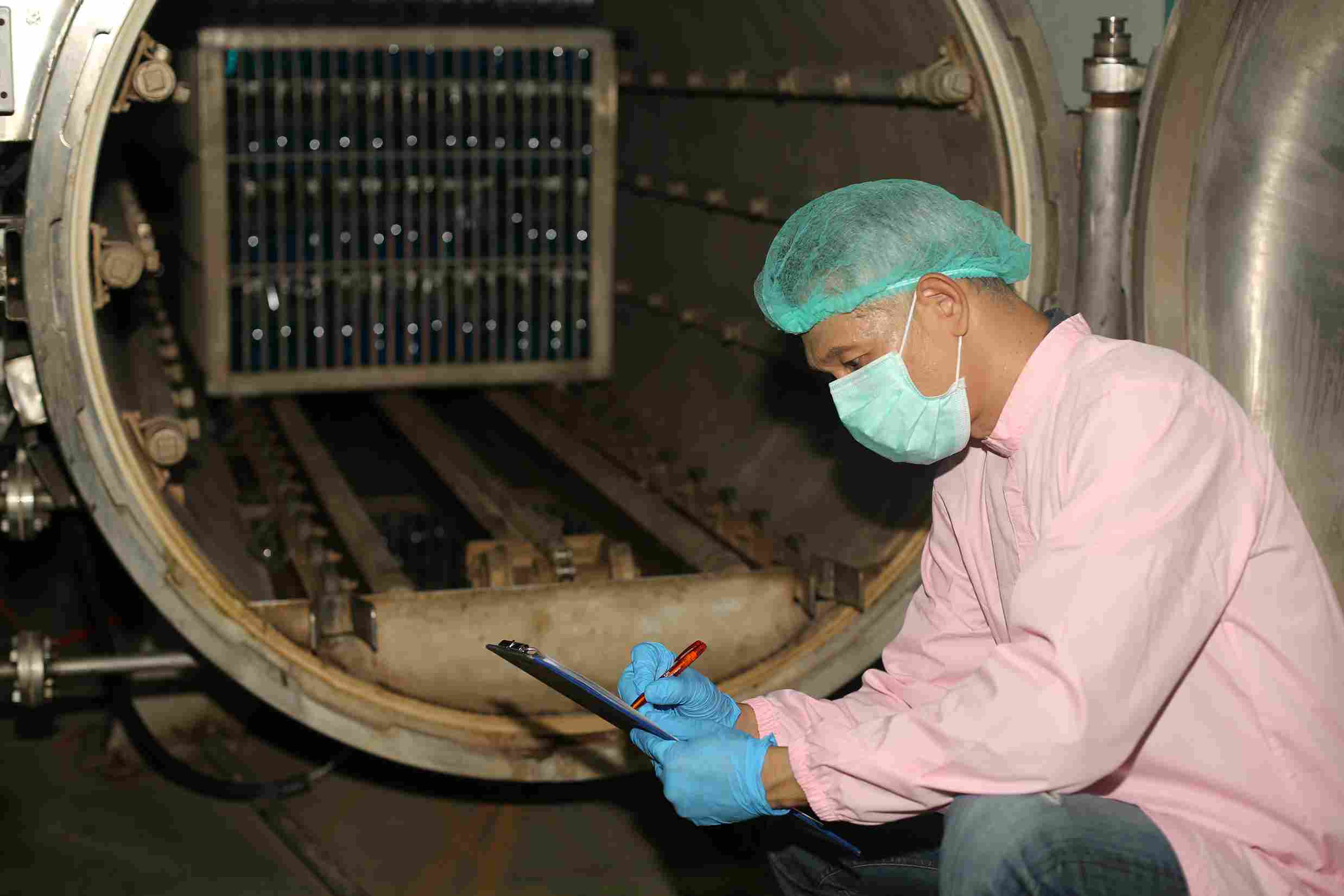 factory-worker-examining-a-bottle-in-factory-tech