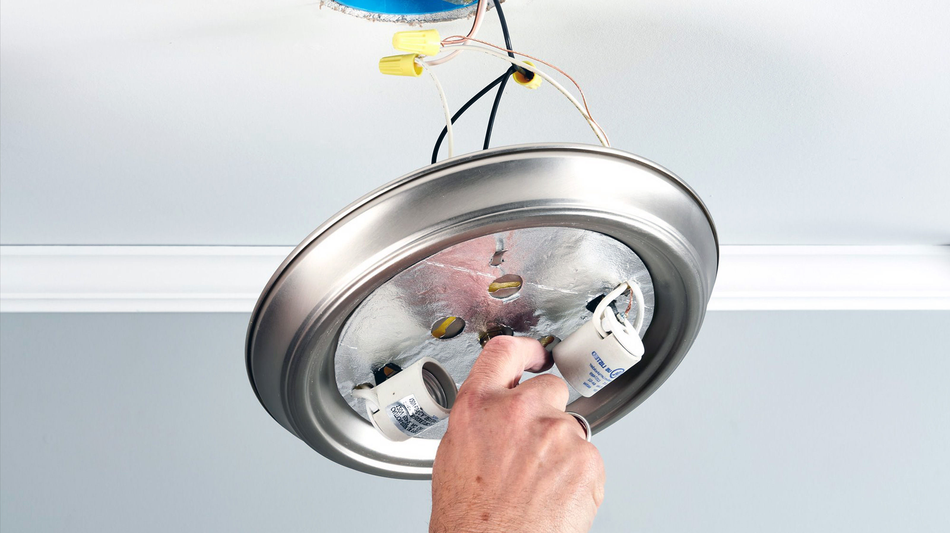 Person Changing Light Bulb In Roof Person Changing Light Bulb In Roof