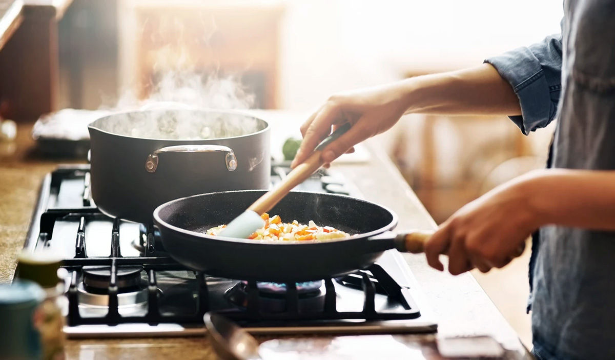 Person Cooking On Gas Stove Top Person Cooking On Gas Stove Top