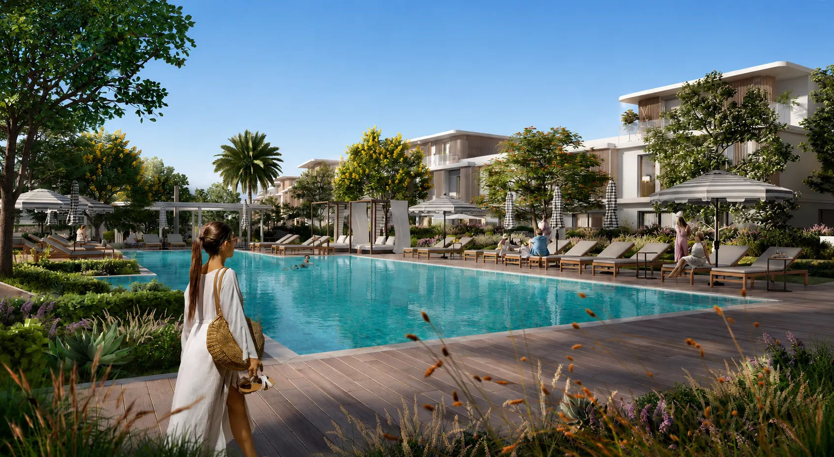 L&T Thanisandra Outdoor swimming pool deck with lounge chairs, parasols, and surrounding villas