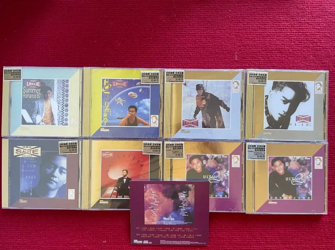 紅色布面上八個張國榮CD透明盒,前方另放一張印有曲目文字的紫色紙件