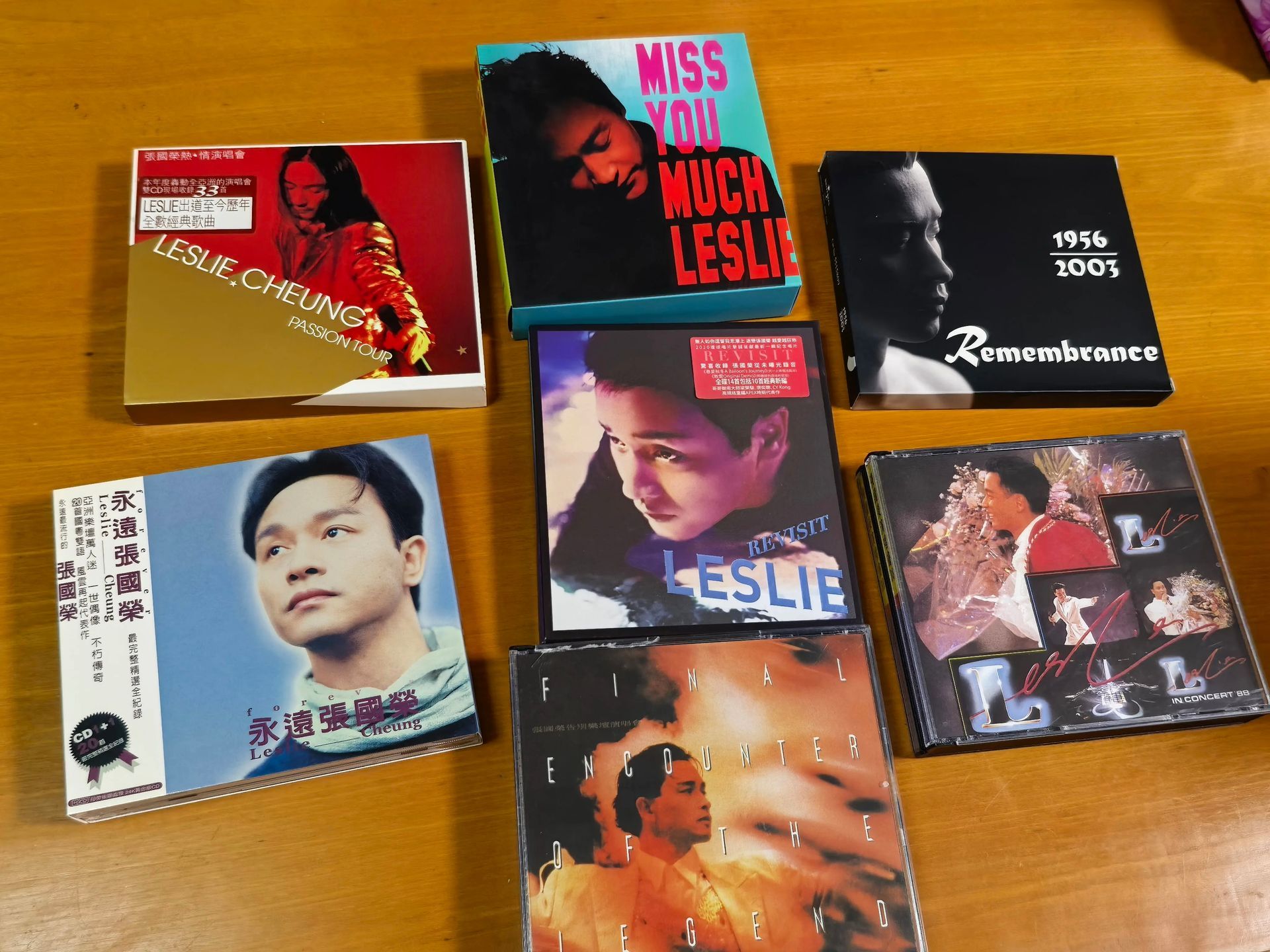 桌上不同盒型的張國榮 CD,包括紙盒與透明光碟盒