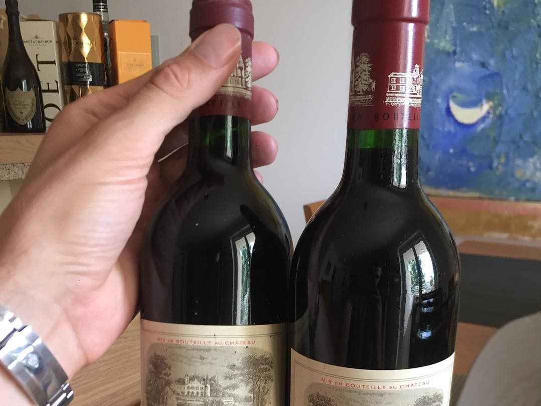 2009 年拉菲正牌紅色膠帽特寫,膠帽印有 LAFITE ROTHSCHILD,瓶身有編碼,後方是木箱