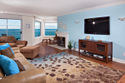 Solana Surfsong - spacious living room with large flat screen TV, fireplace and ocean views