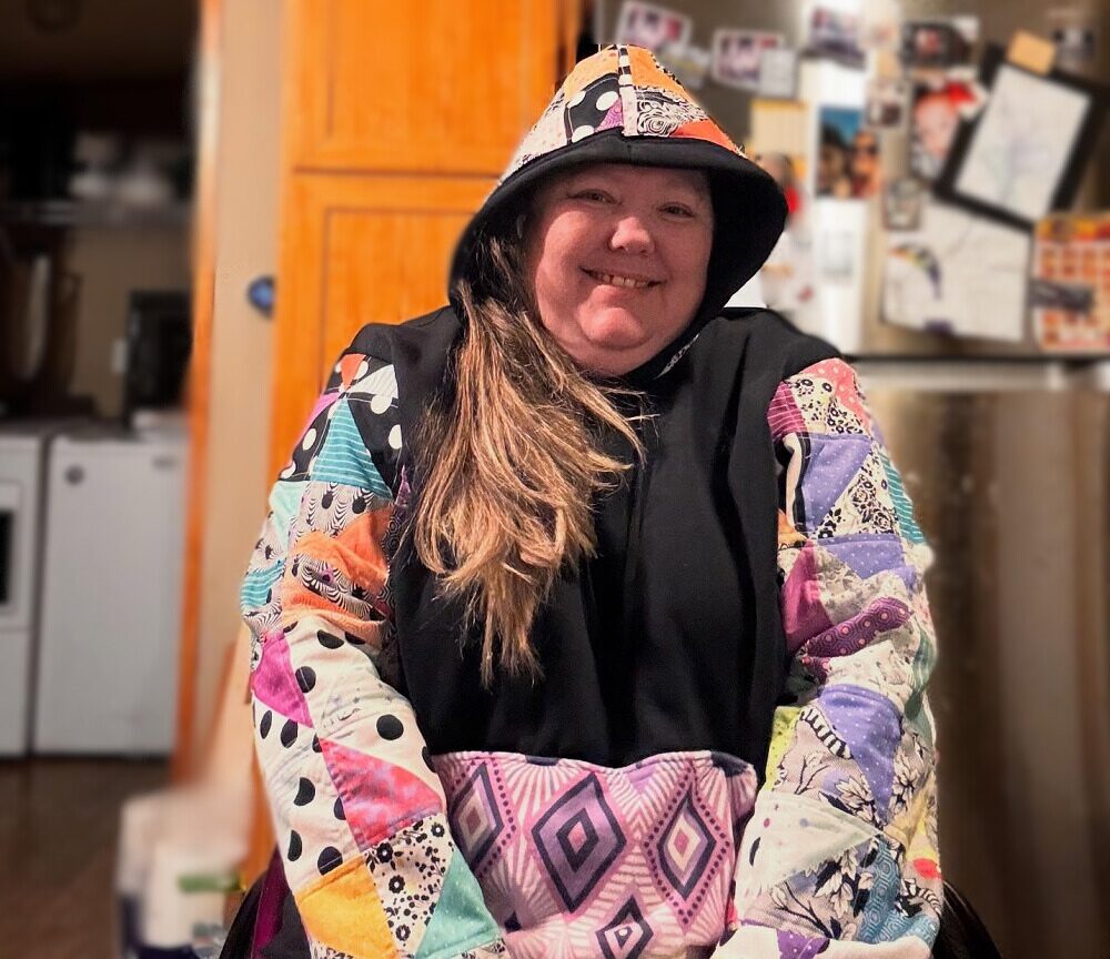 Help Hope Live client Jamie Carlson aka the "Cerebral Palsy Quilter" wearing a quilted hoodie of her own design.