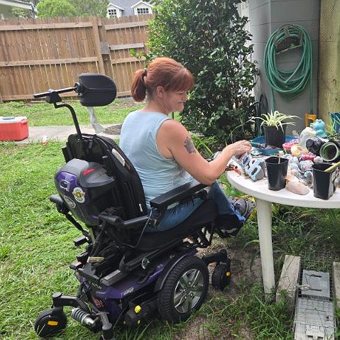 Jennifer French of Sebring Florida pictured tending to plants outside from her power chair.