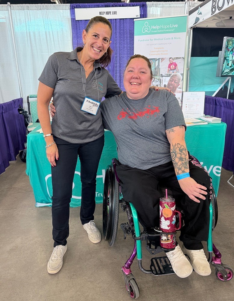 Help Hope Live client Jamie Carlson aka the "Cerebral Palsy Quilter" with Kelly L Green at Abilities Expo Dallas 2024 seated in her wheelchair.