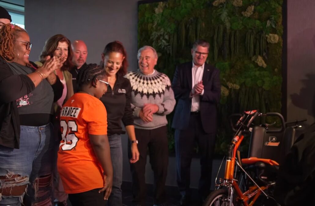 Raymeer Bacon-El receives a new adaptive bike at a 2025 Flyers event.