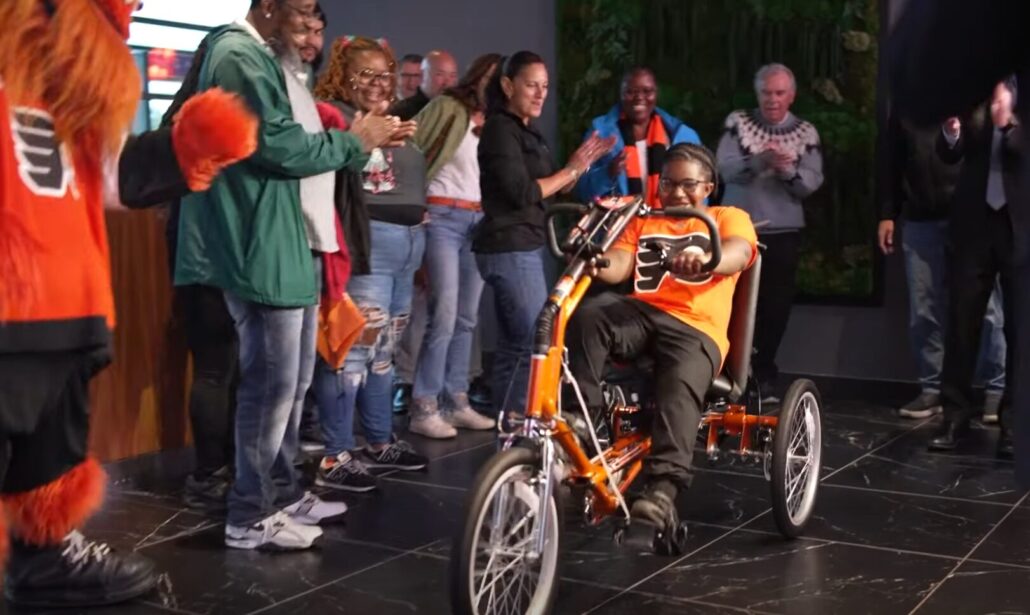 Raymeer Bacon-El receives a new adaptive bike at a 2025 Flyers event.