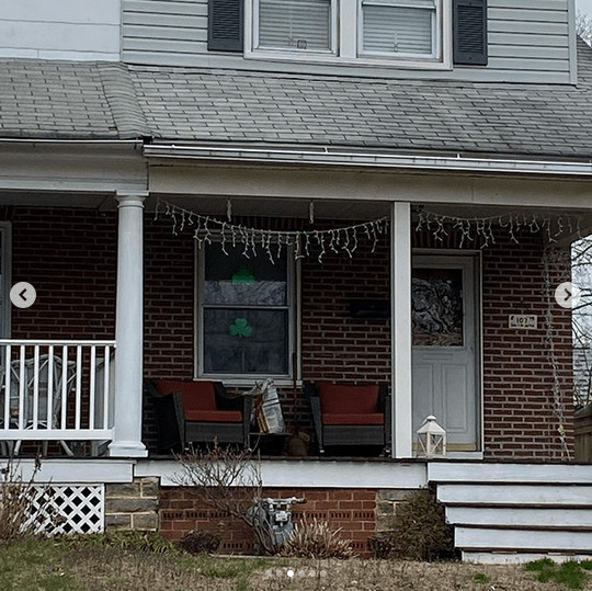 A brick house with a shamrock in one window