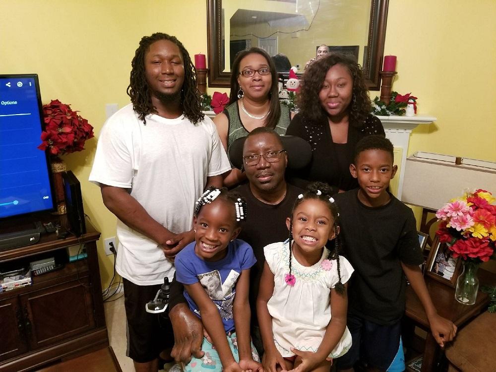 Stephany Golden is in his power chair surrounded by five smiling children and his wife Katrina.