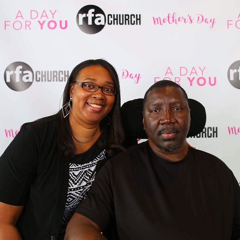 Stephany Golden and his wife Katrina are at an event with a step-and-repeat banner visible behind them.