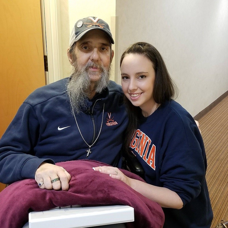 Liver transplant recipient Roger Rudder sits beside his wife, Alana, who was his living liver donor in 2017. Both are smiling.