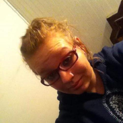 Kidney recipient Deborha has blonde wavy hair, light skin, and glasses with a blue hoodie.