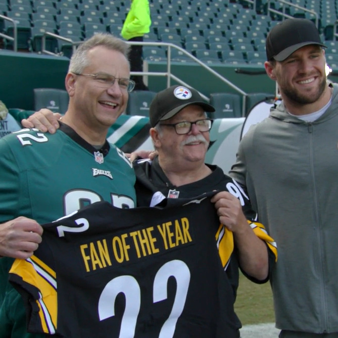 Heart transplant recipient Bill Soloway in an Eagles jersey with Jim Zimmerman, his heart donor's father, as he receives a Fan of the Year black and yellow Steelers jersey from player TJ Watt.