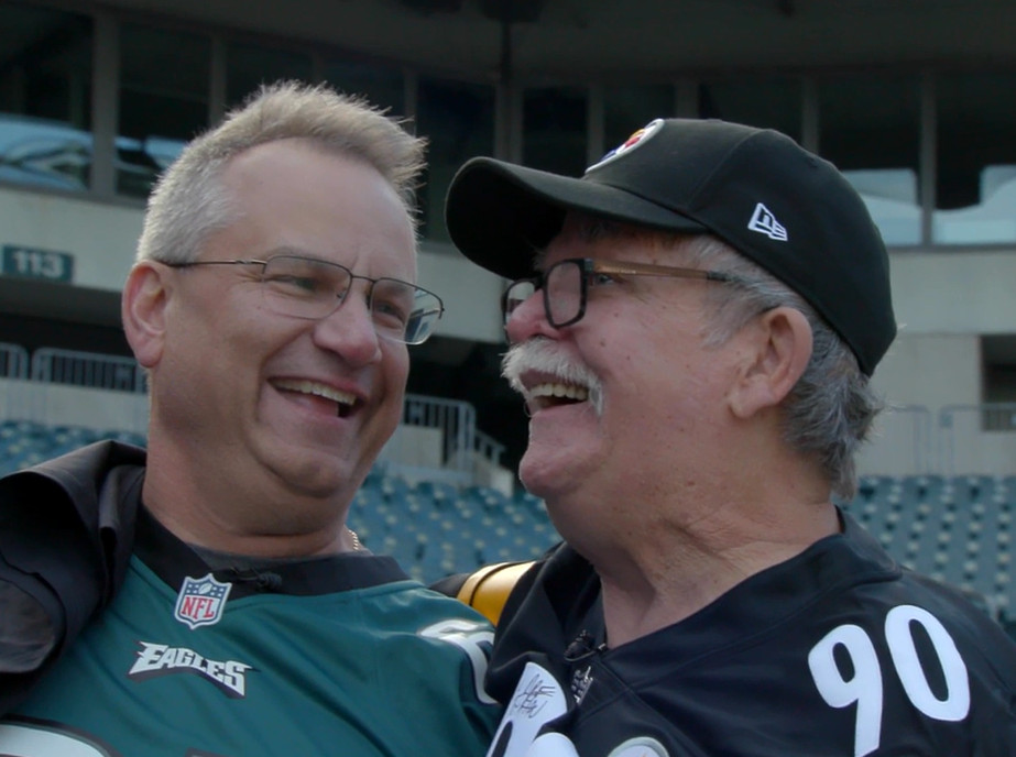 Heart transplant recipient Bill Soloway wears an Eagles jersey as he smiles at Steelers Fan of the Year Jim Zimmerman, father of Bill's heart donor.