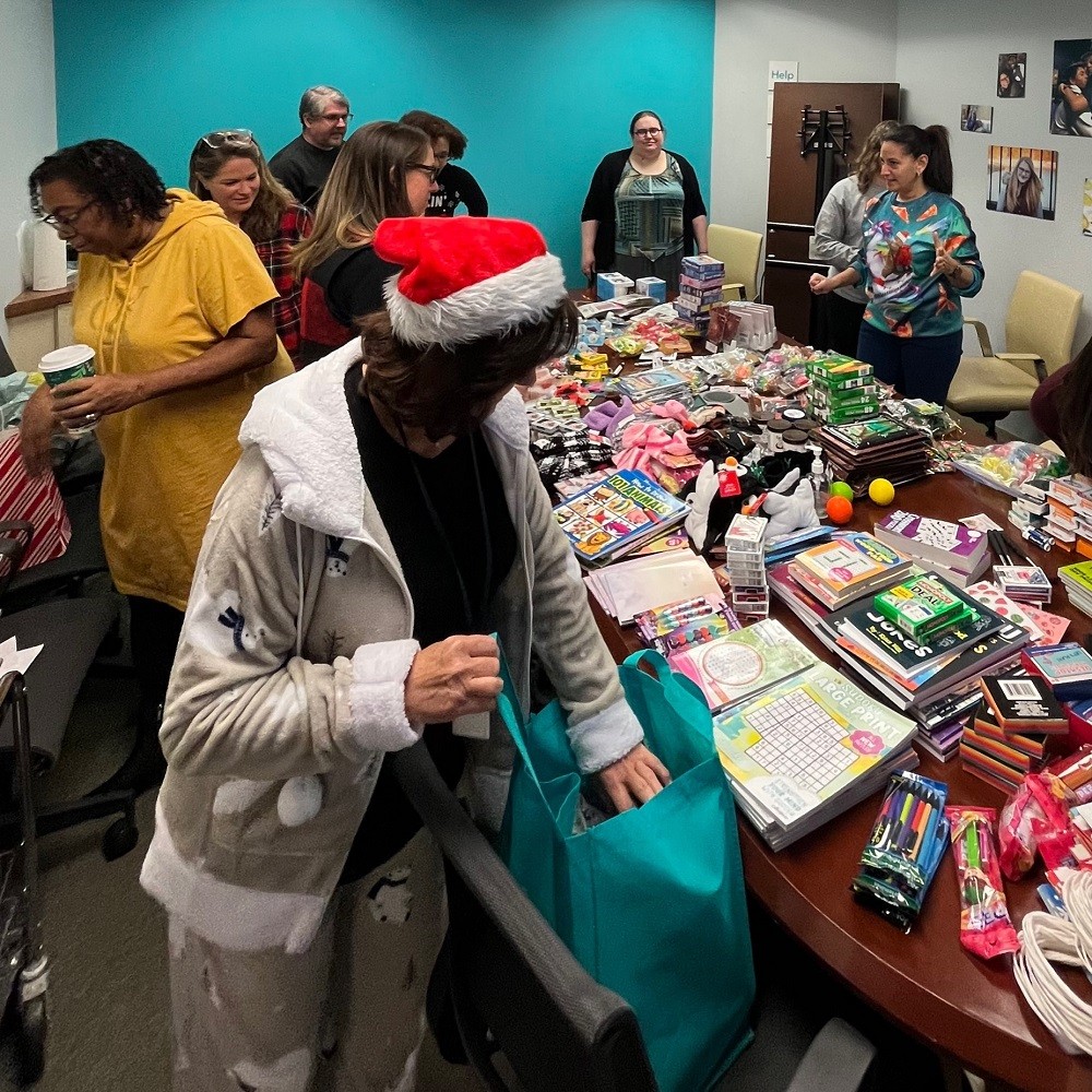 Terri Carlson with staff packing bags of hope at HHL office