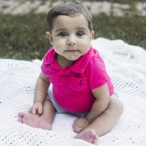Infant liver transplant recipient Theodore has light skin, beautiful eyes, short sandy brown hair, and a bright magenta baby shirt on.