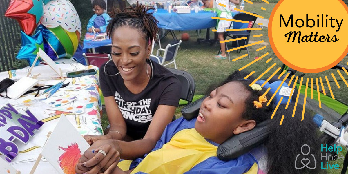 Mom Sierra Dillard holds her daughter Zoë's hand to help her paint at a birthday party activity. Sierra has brown skin, a black t-shirt, braided hair, and hook earrings. Zoë has brown skin and curly black hair. She sits in a supportive mobility device. A graphic button reads Mobility Matters with a sunburst graphic.