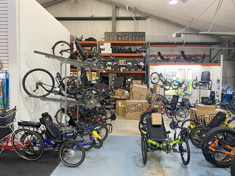 The interior of The Bike Rack in Chicago features multiple displays of adaptive bikes, many with a seat with a backrest, three wheels, and raised pedals.