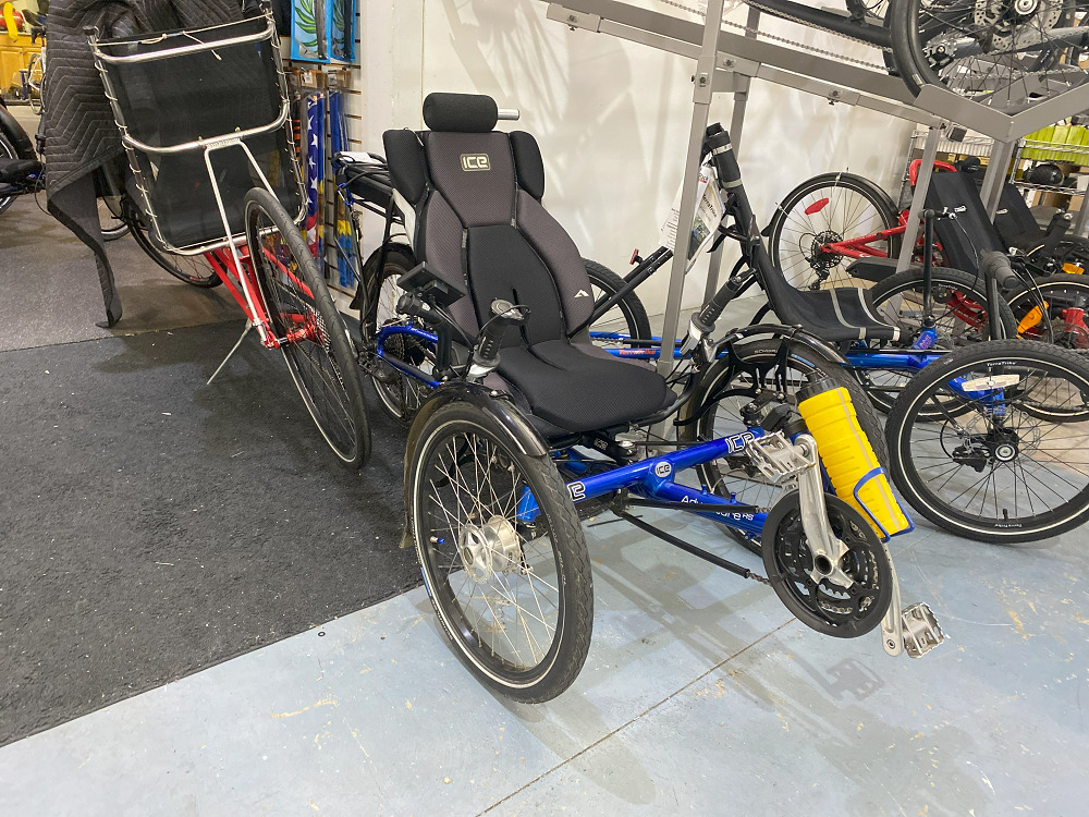 An adaptive bike at The Bike Rack in Chicago with three wheels and a seated pedal mechanic.